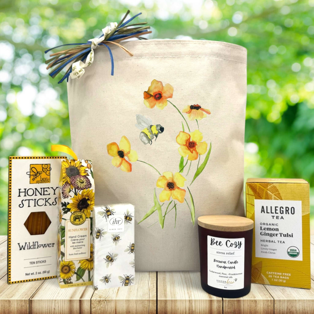 Bee-themed gift basket with honey, tea, candle, and hand cream