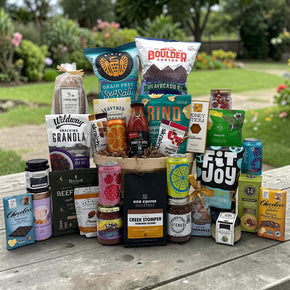 bushel filled with a variety of snacks, popcorn, chips, pancake mix, drinks, candies, tea, coffee and more