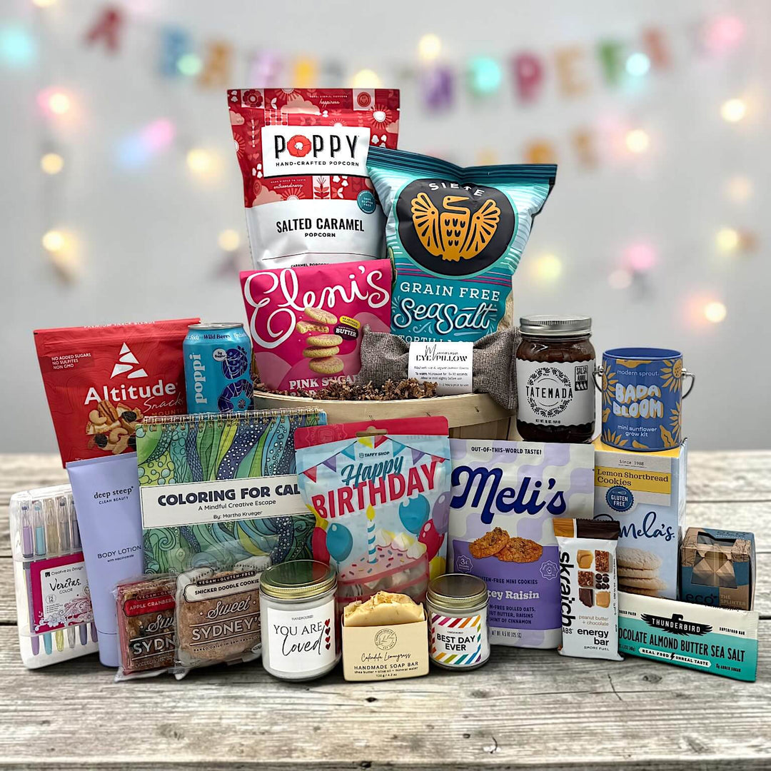 Bushel basket filled with  variety of snacks, popcorn, chips, spa items, candles, lotion, eye pillow and more