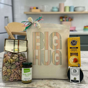 Striped "Big Hug" design on tote bag with pasta, pesto, bruschetta, and crackers sitting on table