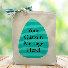 A Blue striped Easter egg with a chance to place a custom message inside, set on a wood table with green blurred background 