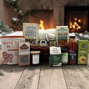 Gourmet Christmas gift basket with a blanket, pasta and sauce, pretzels, caramels, a candle, tea and more