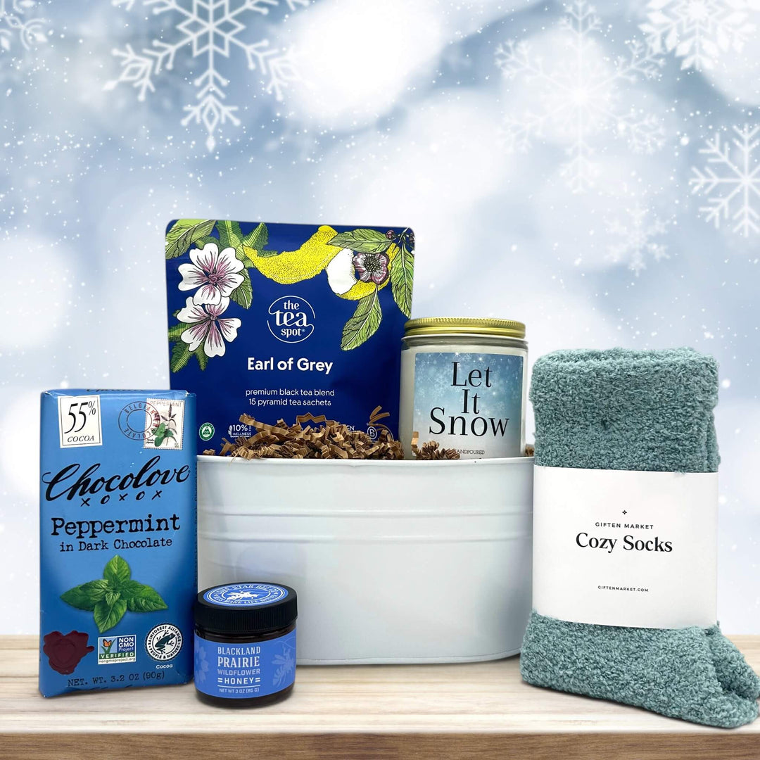 small tin tub with tea, a large candle, honey, chocolate bar, and socks all themed in the color blue