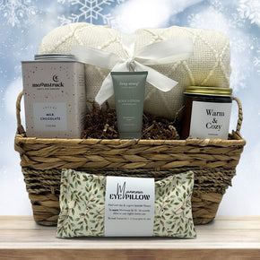 gourmet holiday gift basket with a blanket, cocoa, lotion, a large candle and an eye pillow