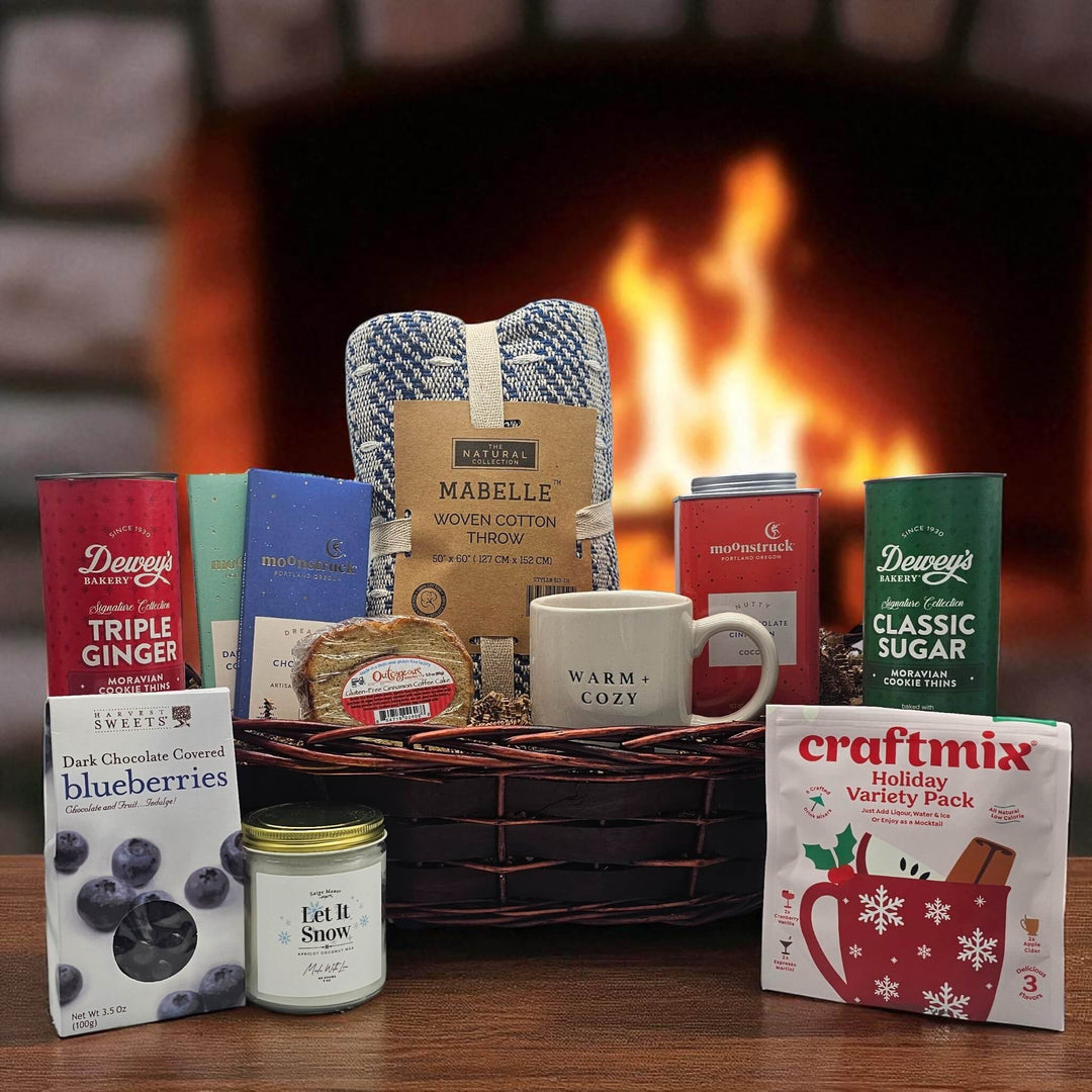 Gourmet holiday appreciation gift with a blanket, chocolate bars, cookies, mug, candle, bread, and more snacks