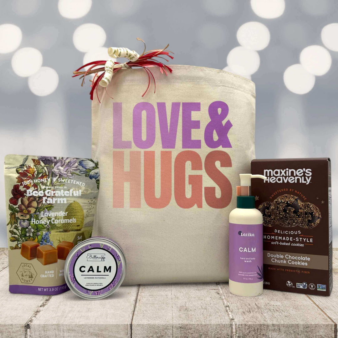 Love and hugs printed on tote bag with caramels, candle, lotion and cookies sitting on a table