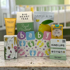baby gift box filled with hand cream tissues, tea, lemon buds, hand sanitizer, lip balm, sitting on a table