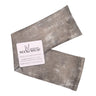 Grey neckwrap filled with lavender and rice laying on table with manorosa branded tag
