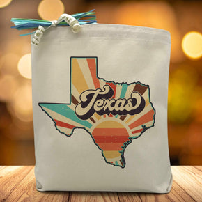 A retro styled sunrise in the shape of the Texas State with the word Texas placed in the middle printed on a canvas tote bag placed on a wooden table 