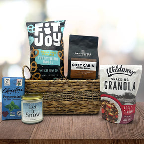 wicker basket with pretzels, coffee, chocolate bar, large candle and granola