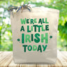 We're all a little irish today printed in green on a canvas tote bag sitting on a table