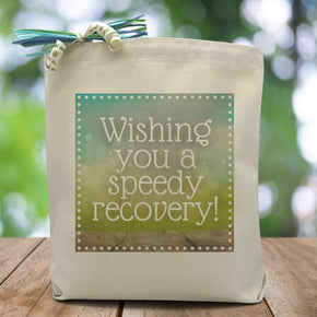a blue and green box with the text wishing you a speedy recovery placed in the middle printed on a canvas tote bag. 