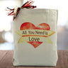all you need is love printed on a red heart on a canvas tote bag