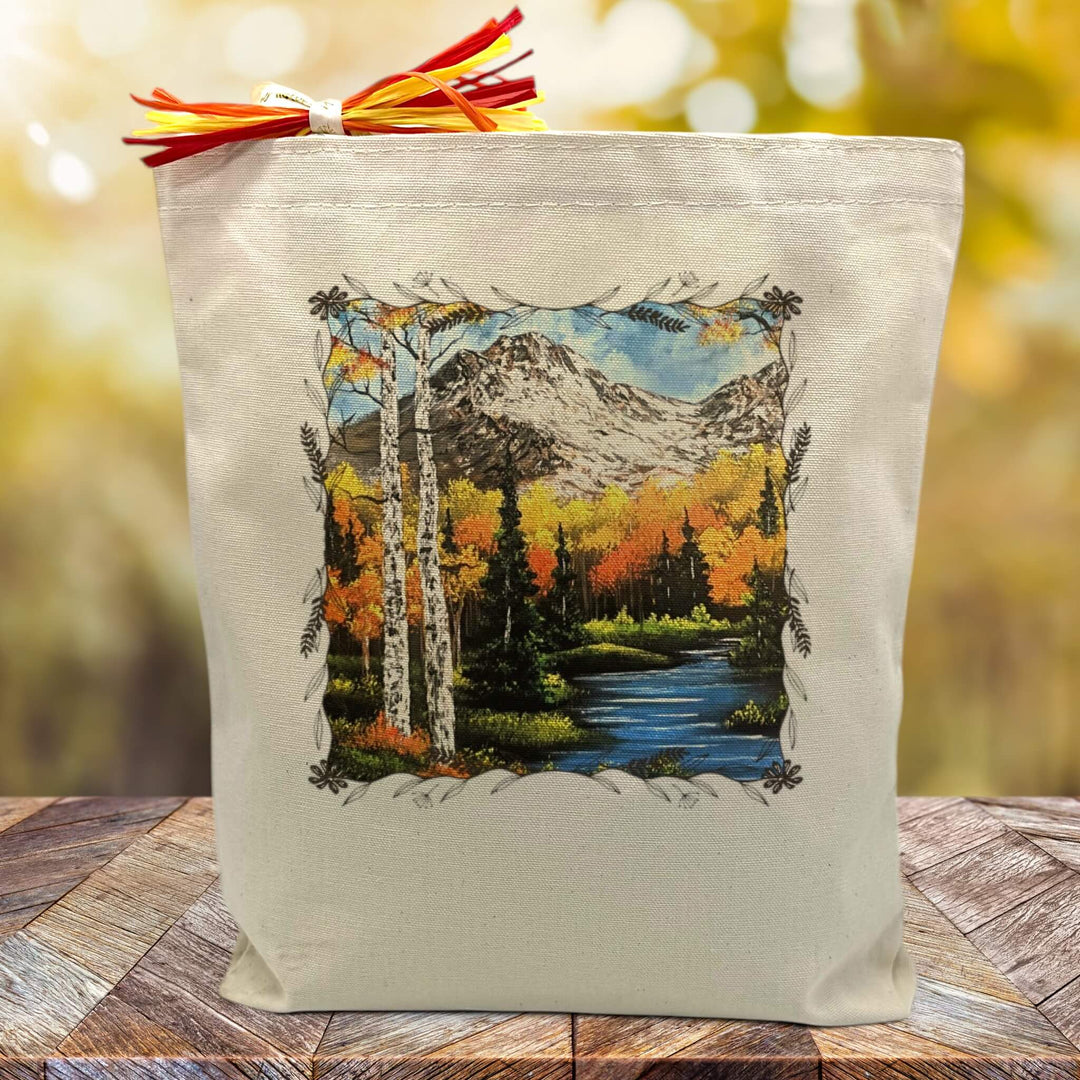 autumn nature scene printed on a canvas tote bag sitting on a table
