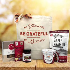 Gourmet thanksgiving basket with cookies, chocolate, jam, oatmeal and granola sitting on a table