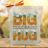 Big colorado hug with an autumn print printed on a canvas tote bag sitting on a wood table