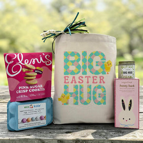 Easter gift basket with cookies, an egg coloring kit, chocolate bar, and candle