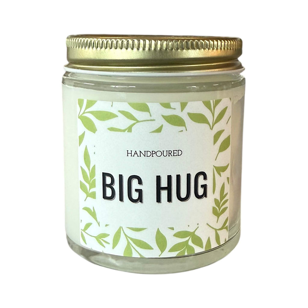 Candle with Big Hug Printed on the front with green leaves around