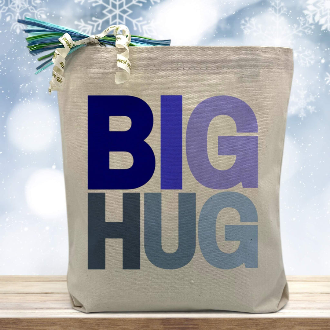blue big hug printed on a canvas tote bag sitting on a table