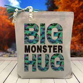 Big Monster hug printed on canvas tote bag sitting on a table with a blurred fall background