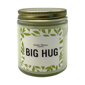 big hug candle with green leaves around