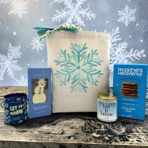 winter gift with a plant grow kit, a chocolate bar, a large candle and cookies