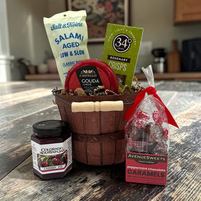Apple bushel basket with salami, crackers, cheese, jam, and caramels