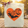 Orange heart with bats inside printed on a canvas tote bag sitting on a table