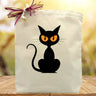 Black cat printed on a canvas tote bag sitting on a table 