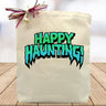 Happy haunting printed on a canvas tote bag sitting on a table