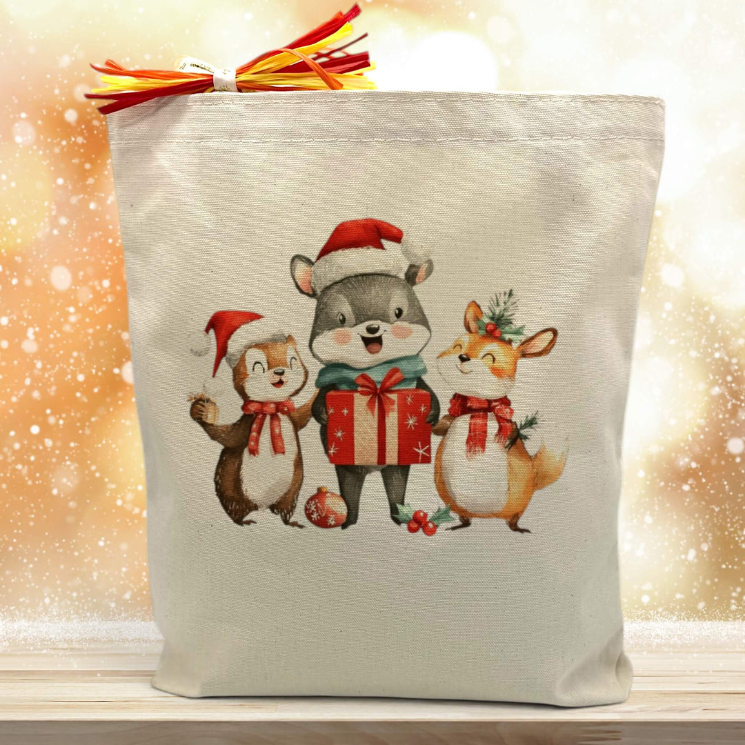 3 christmas themed critters printed on a canvas tote bag sitting on a wood table with a gold background