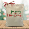 red and green merry christmas printed on a canvas tote bag sitting on a wood table