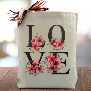 love with flowers printed on a canvas tote bag sitting on a table with a blurred white background