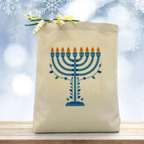 hanukkah candles printed on a canvas tote bag sitting on a table with a blurred blue background