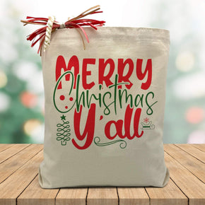 merry christmas yall in red and green printed on a canvas tote bag sitting on a wood table