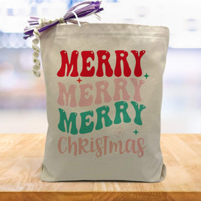 colorful merry merry merry christmas printed on a canvas tote bag sitting on a wood table