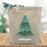 christmas tree printed on a cavnas tote bag sitting on a table with a blurred christmas tree background