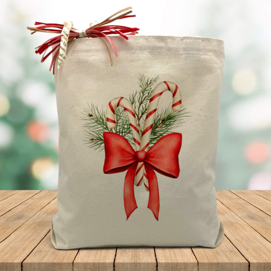peppermint canes with a bow printed on a canvas tote bag sitting on a table with a blurred background