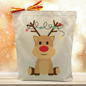 cartoon holiday themed reindeer printed on a canvas tote bag sitting on a wood table with a gold background