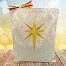 yellow start printed on a canvas tote bag sitting on a wood table