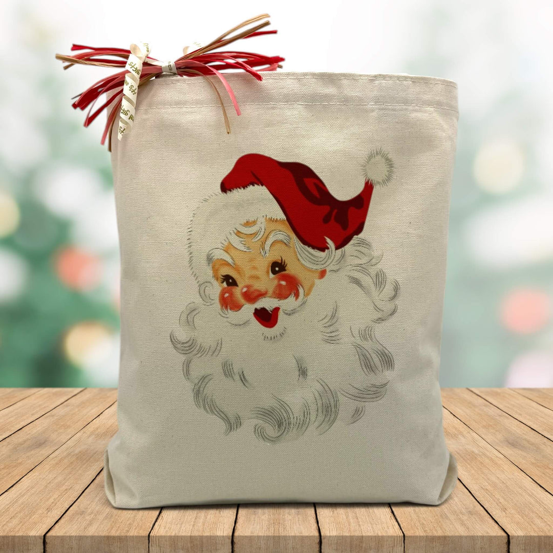 santa claus printed on a canvas tote bag sitting on a wood table with a holiday background