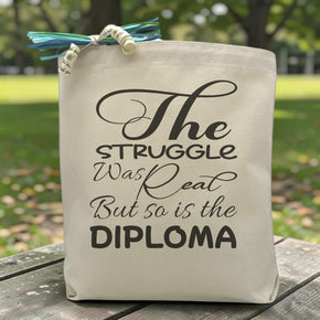 the sturggle was real but so is the diploma printed on a canvas tote bag