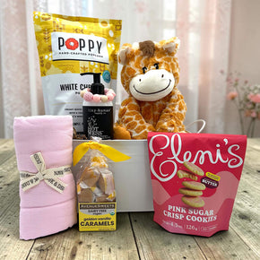 white tin tub with popcorn, baby shampoo, teething ring, swaddle, caramels and cookies