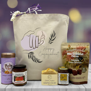 tote bag sitting on table with tea jam soap honey and caramels