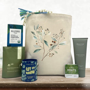 Gourmet holiday gift basket with tea, bath salts, a plant grow kit, pepermint mints, and rosemary lotion