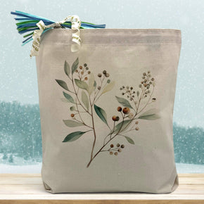 Eucalyptus branch printed on a canva tote bag sitting on a table with a snowflake background