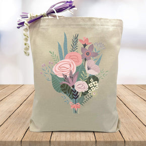 pink and blue flower bouquet printed on canvas tote bag sitting on table with white blurred background