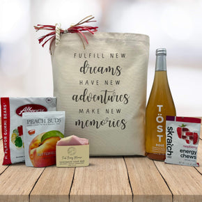 fulfill new dreams quote on canvas tote bag with gummies, peach buds, soap, sparking juice, and energy chews