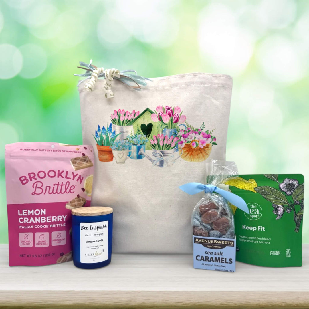 flowers surrounding a bird house with a watering can printed on a back with snacks and a candle sitting on a table