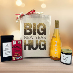 Gourmet new year gift basket with cocoa, chocolate, a large candle and sparkling juice